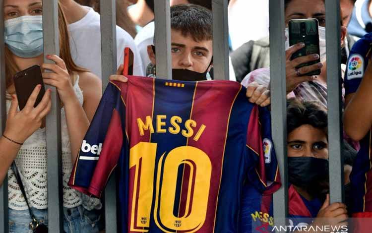 Seorang fans memegang jersey Barcelona bernomor punggung 10 miliki Lionel Messi ketika konferensi pers di Stadion Camp Nou, Barcelona, 8 Agustus 2021