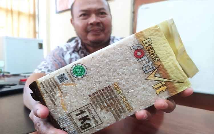 Kepala Bulog Sub Divre Sampit, Rony Hadianto memperlihatkan beras bervitamin yang diproduksi pihaknya.