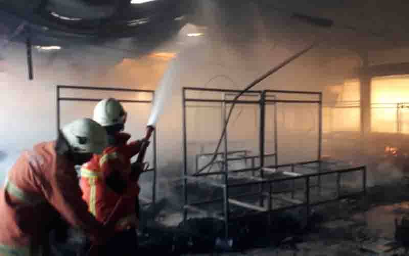 Sejumlah petugas Pemadam Kebakaran (PMK) Surabaya tampak memadamkam api di Pasar Kembang Kota Surabaya yang terbakar pada Minggu (22/8/2021) sore. (foto : ANTARA/HO-Tommy-PMK Surabaya)