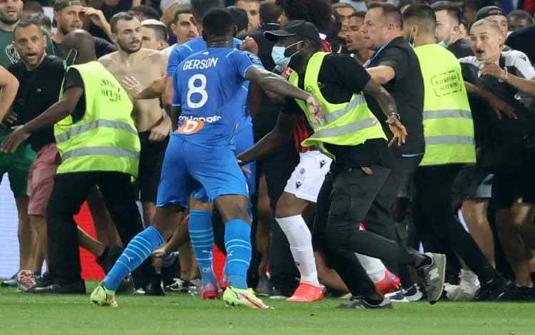 Petugas keamanan berusaha mencegah suporter yang berusaha menduduki lapangan dalam laga Liga Prancis antarfa OGC Nice dan Olympique de Marseille di Stadion Allianz Riviera di Nice, Prancis, 22 Agustus 2021