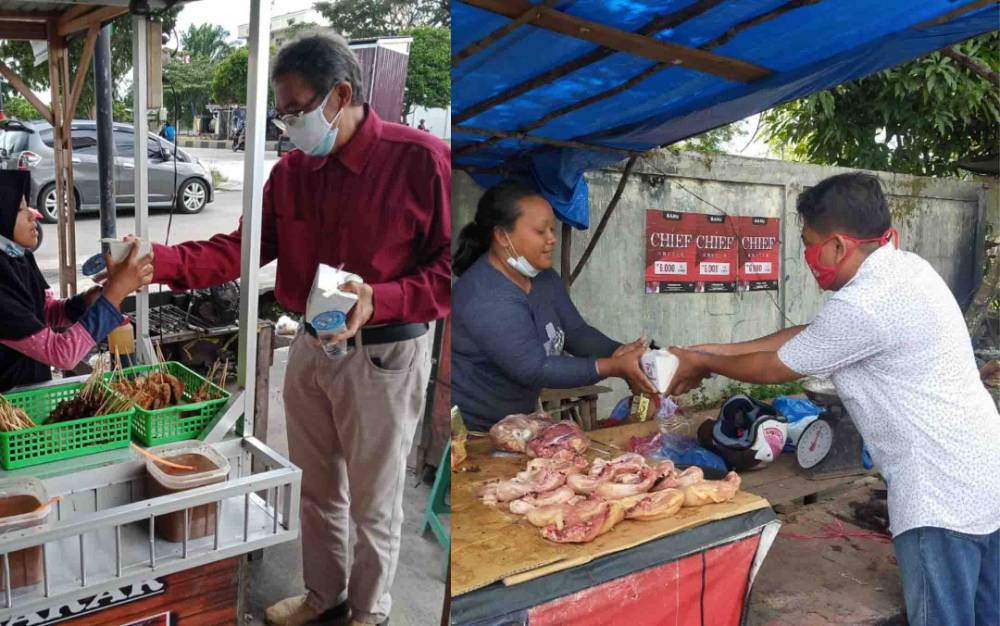 Bendahara dan Sekretaris PSI bagikan rice box kepada pekerja informal di Kota Palangka Raya.