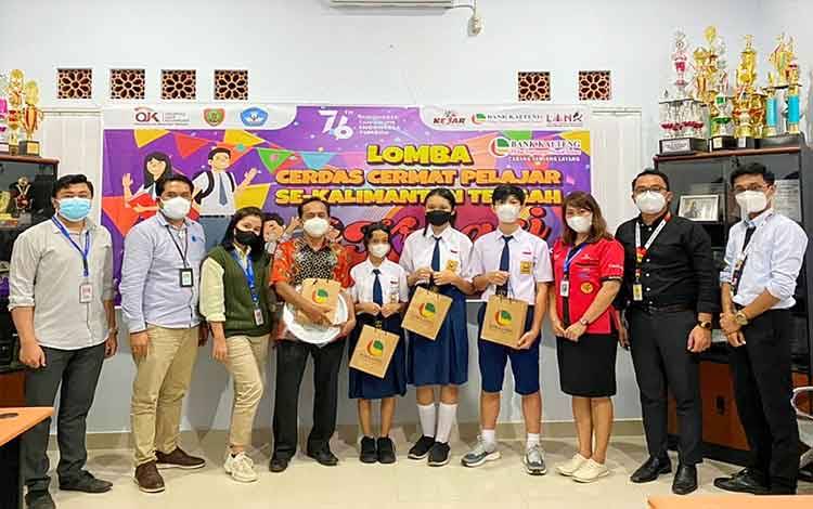 Tim cerdas cermat SMPN 1 Tamiang Layang berfoto bersama dengan pegawai Bank Kalteng Cabang Tamiang Layang.
