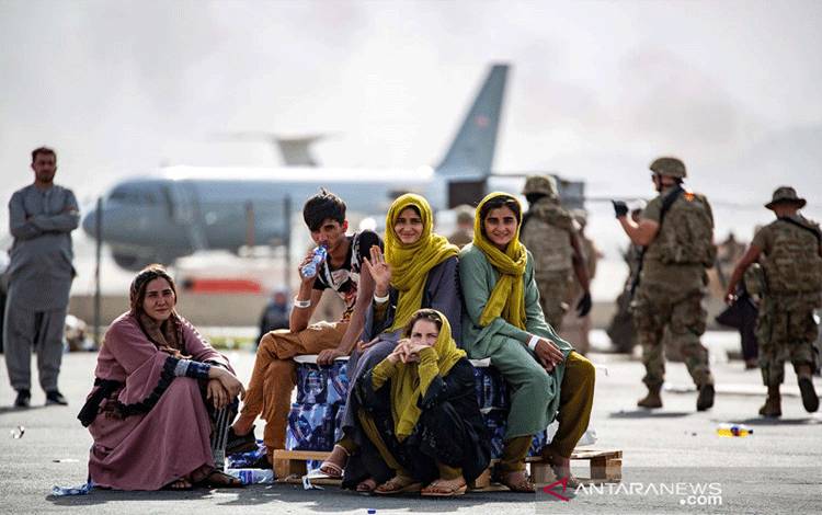 Pengungsi anak-anak menunggu penerbangan berikutnya setelah didaftarkan di Bandara Internasional Hamid Karzai, di Kabul, Afghanistan, Kamis (19/8/2021). Gambar diambil 19 Agustus 2021. 1stLt. Mark Andries/U.S. Marine Corps/Handout via REUTERS/AWW/djo