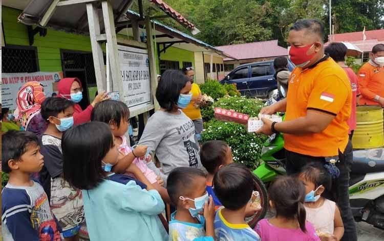 Kepala Satpol PP Kota Palangka Raya Yohn Benhur G Pangaribuan berbagi bantuan untuk anak-anak korban kebakaran   