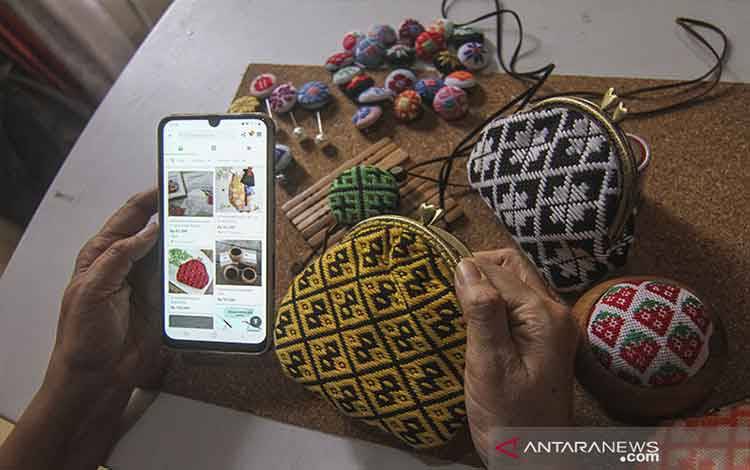 Perajin melihat stok kerajinan aksesori koginsashi miliknya pada aplikasi jual beli di Asriku Kreasi, Depok, Jawa Barat, Minggu (1/8/2021). Kementerian Koperasi dan Usaha Kecil dan Menengah (Kemenkop UKM) mengatakan baru 13,7 juta dari 64 juta pelaku UMKM yang sudah Go Digital dan menargetkan 30 juta pelaku UMKM telah Go Digital pada 2024 mendatang. ANTARA FOTO/Asprilla Dwi Adha/aww. (ANTARA FOTO/ASPRILLA DWI ADHA)