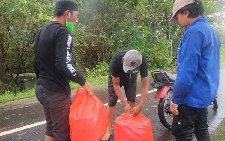  Ketua KNPI Katingan Budy Hermanto menyerahkan nasi bungkus kepada warga terdampak banjir