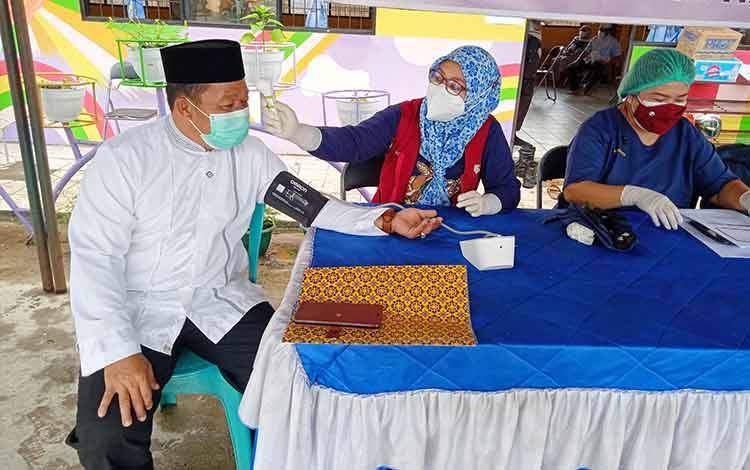 Kepala Kantor Kementerian Agama Kabupaten Barito Timur, H Abdul Majid Rahimi mengikuti vaksinasi covid-19 di Masjid Agung Ar-Rahman Tamiang Layang.