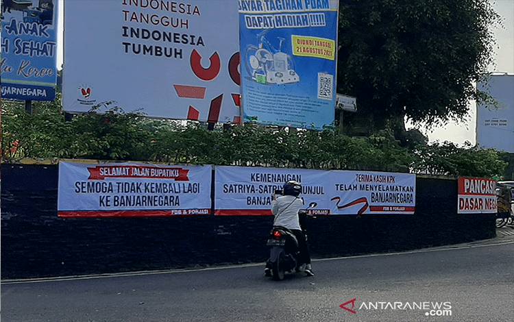 Seorang warga memotret spanduk yang terpasang di sekitar Alun-Alun Banjarnegara, Sabtu (4/9/2021), salah satunya bertuliskan ucapan terima kasih kepada KPK. (ANTARA/Sumarwoto)