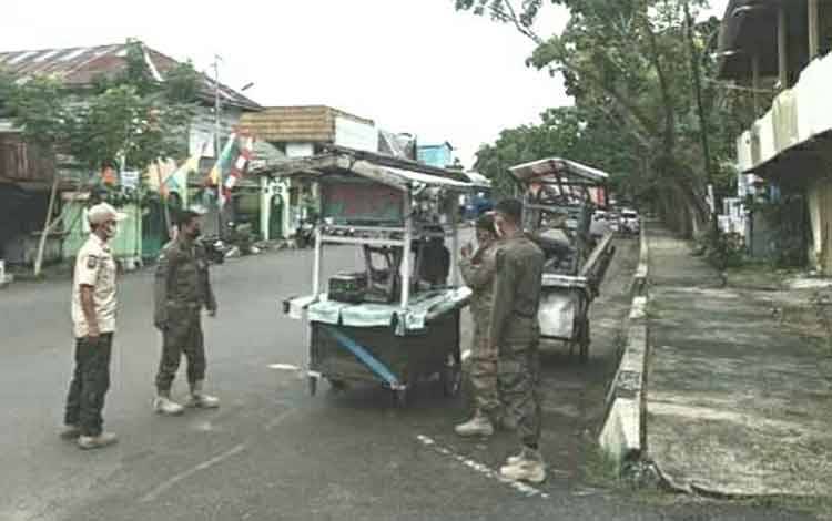 Personel Satpol PP dan Damkar Kapuas saat menertibkan gerobak pedagang terparkir halangi jalan.