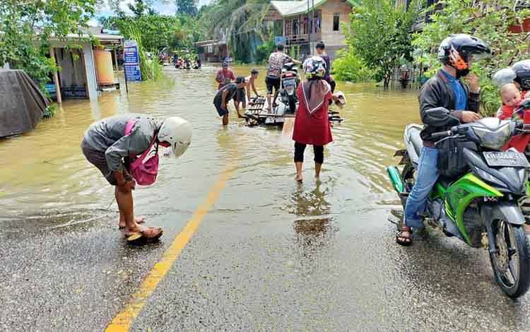 Babinsa Koramil 1013-03 Teweh Tengah saat memantau kondisi banjir di Kelurahan Jambu, Kecamatan Teweh Baru