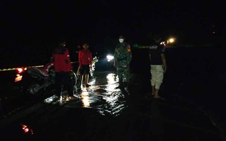 Petugas gabungan bersiaga di lokasi genangan air ruas jalan Jenderal Sudirman Km 122 Desa Asam Baru, tadi malam.