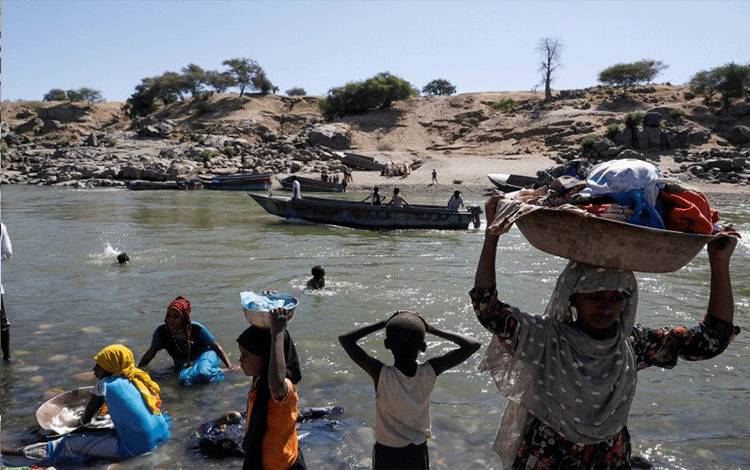 Arsip - Pengungsi beraktivitas di tepi sungai Ethiopia yang memisahkan Sudan dan Ethiopia di dekat kamp transit pengungsi Hamdeyat, perbatasan Sudan-Ethiopia, Sudan, November 2020. (ANTARA/Reuters)