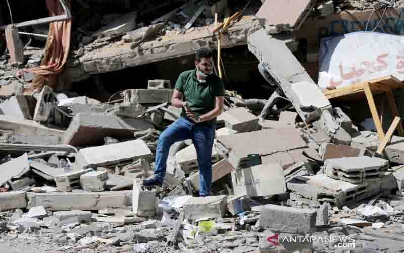  Warga Palestina Shaban Esleem berdiri di antara reruntuhan toko bukunya yang hancur akibat serangan udara Israel selama pertempuran Israel-Palestina, di Kota Gaza, Senin (24/5/2021). (foto : REUTERS/Ibraheem Abu Mustafa/HP/djo)