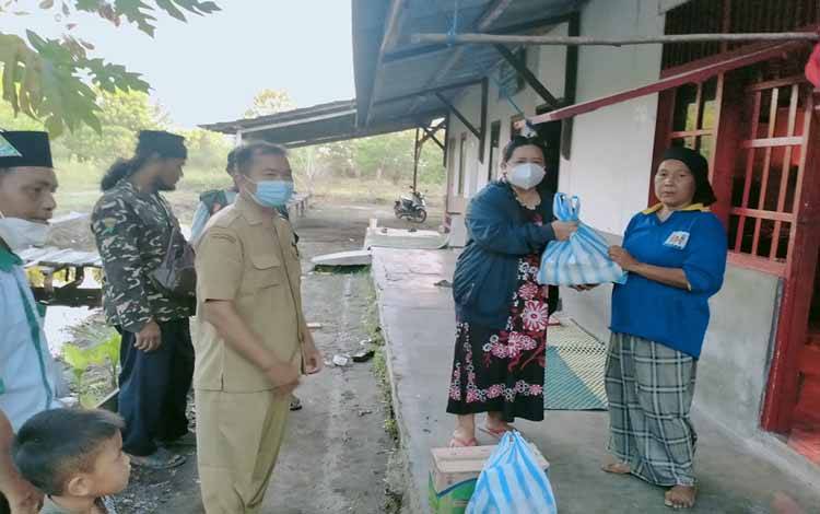 Ketua Ikatan Guru Indonesia (IGI) Kota Palangka Raya, Hartani memberikan bantuan sembako kepada seorang janda, Senin 13 September 2021