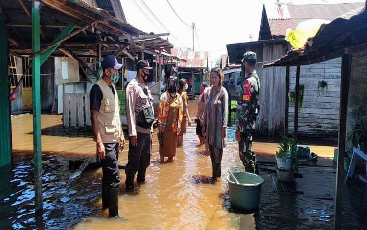Kasi Kesos Kelurahan Langkai, Sri Wanti bersama jajaran Polri dan TNI mengecek banjir di Flamboyan bawah, Senin 13 September 2021