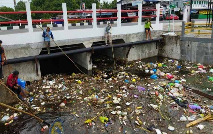 Petugas saat membersihkan sampah pada saluran drainase di Palangka Raya