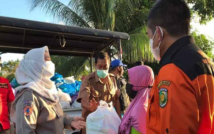 Kepala BPBD Palangka Raya, Emi Abriyani beserta tim menyerahkan bantuan sembako kepada warga terdampak banjir