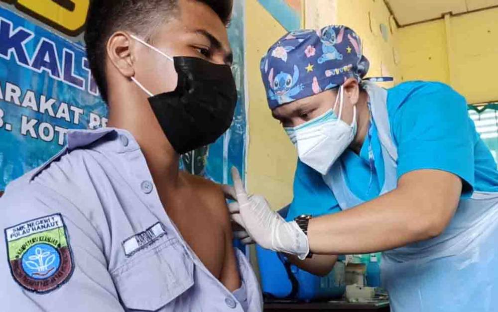 Seorang siswa SMK N 1 Pulau Hanaut, menjalani vaksinasi yang diinisiasi Ditpolair Polda Kalteng