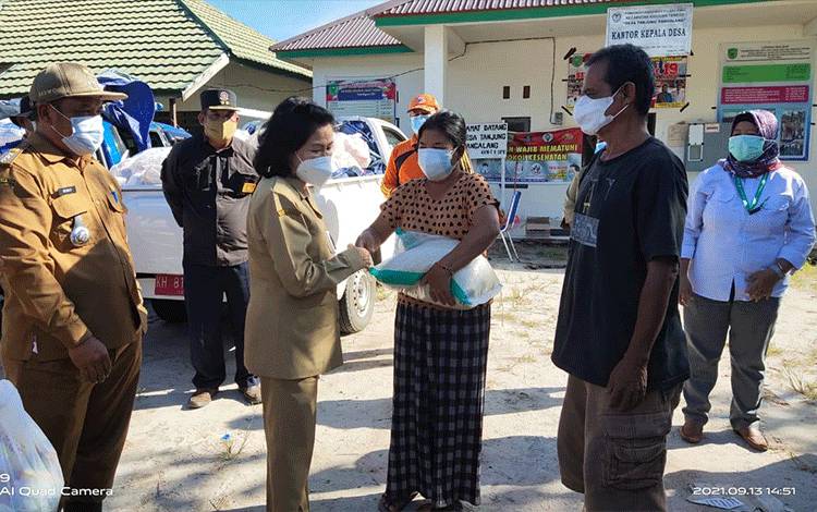 Bupati Pulpis didampingi pijat terkait menyerahkan bantuan bagi korban banjir Kecamatan Kahayan Tengah, Senin (13/09/2021).