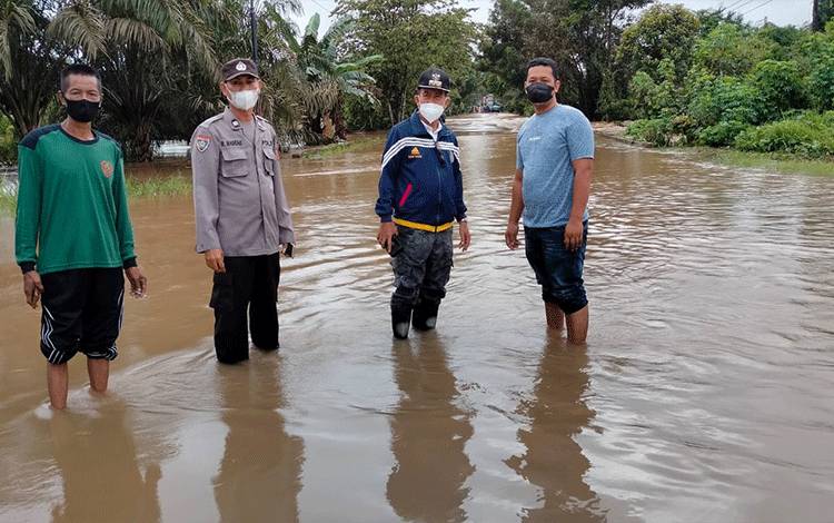 Personel Polres Seruyan bersama Camat Danau Seluluk, saat mengecek kondisi ruas jalan Jendral Sudirman Km 109 Desa Rungau Raya yang tergenang banjir.
