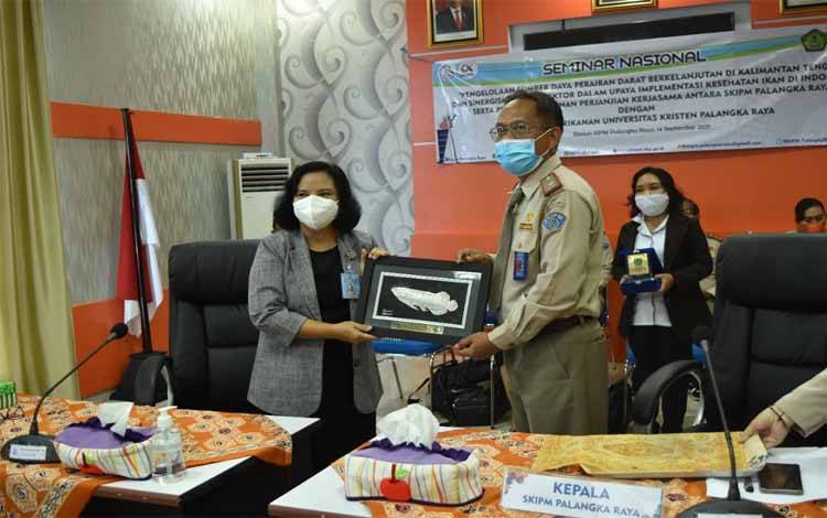 Kepala Stasiun KIPM Palangka Raya, Iromo menyerahkan dokumen MoU kepada Dekan Fakultas Perikanan UNKRIP, Infa Minggawati 