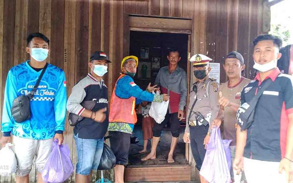 Relawan gabungan bersama anggota Polsek Pematang Karau menyalurkan makanan siap saji kepada warga yang terdampak banjir.