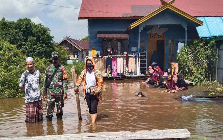 Kasi Kesos Kelurahan Langkai, Sri Wanti bersama Babinsa melihat kondisi warga terdampak banjir