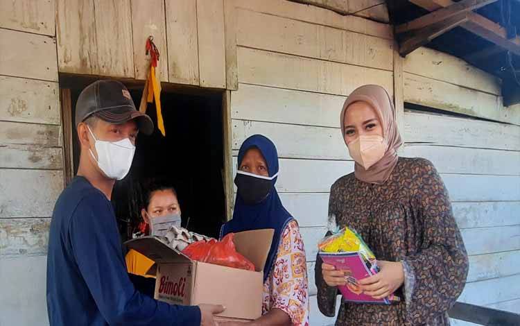 Anggota DPRD Kobar Wanti Septia Utami (kanan) saat turut serta menyalurkan bantuan untuk warga terdampak banjir di Kelurahan Raja Seberang