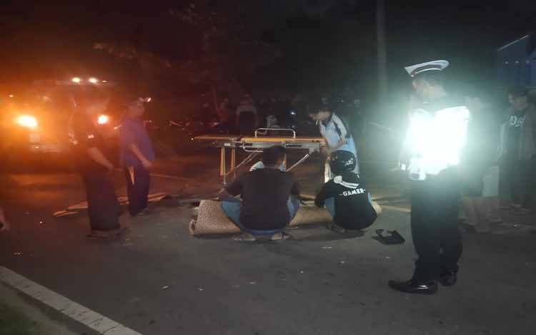 Sejumlah kepolisian dan warga saat mengevakuasi korban kecelakaan di Jalan Jendral Sudirman Km 41, Desa Penyang, Kecamatan Telawang