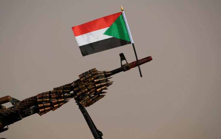 Bendera nasional Sudan dipasang pada senapan mesin paramiliter RSF saat menunggu kedatangan Letjen Mohamed Hamdan Dagalo, wakil kepala dewan militer dan kepala RSF, sebelum pertemuan di desa Aprag, Sudan, Juni 2019