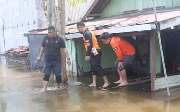 Camat Kamipang, Ade Irwan (kanan)  mengecek banjir di wilayahnya. 