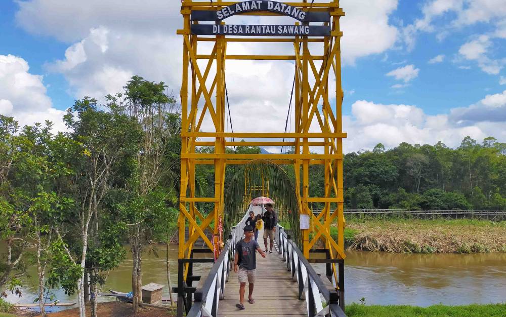 Sejumlah warga melintasi Jembatan Gantung di Desa Rantau Sawang.
