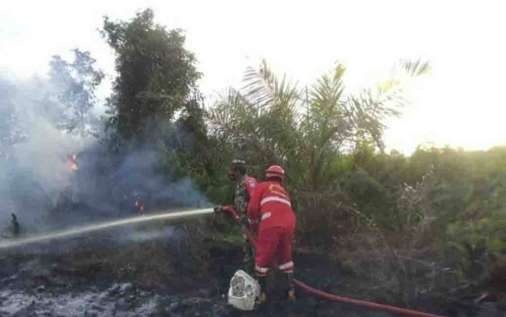 Tim Satgas Penanganan Karhutla Kobar saat berjibaku memadamkan api di lahan yang berada di Jalan Lintas Kotawaringin Lama Km 18, Kelurahan Mendawai Seberang.