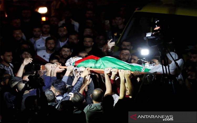 Warga membawa jenazah Mohammed Khabisah Palestina yang meninggal setelah ditembak oleh pasukan Israel dalam bentrokan untuk dimakamkan di Beita, Tepi Barat yang diduduki Israel, Jumat (24/9/2021). (ANTARA/Reuters/as)