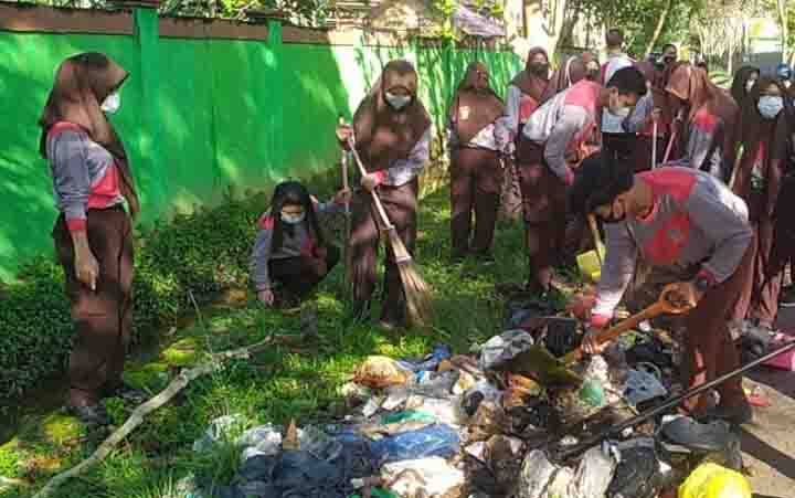 Sejumlah pelajar saat membersihkan sampah di Jalan Ki Hajar Dewantara, Kecamatan Baamang.