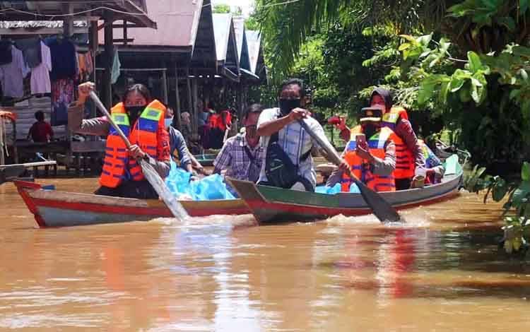 Penyaluran paket sembako kepada warga terdampak banjir menggunakan perahu