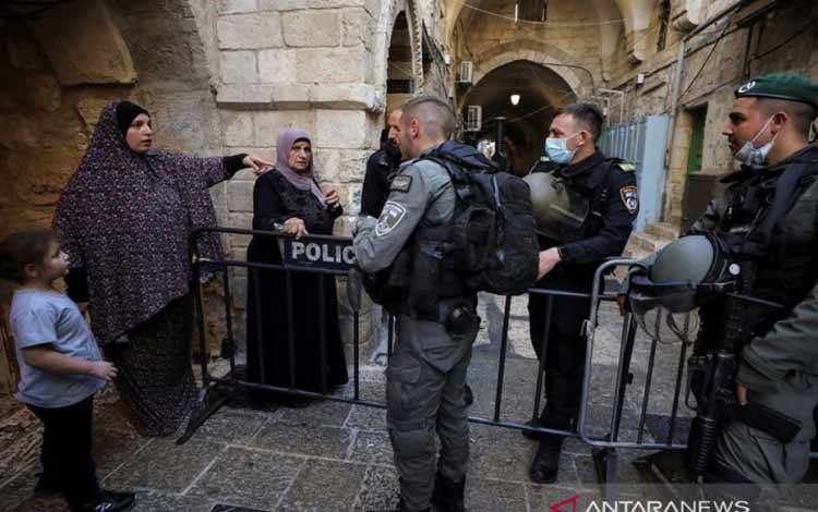 Seorang warga berbicara dengan sejumlah polisi perbatasan Israel saat mereka berjaga di dekat lokasi dugaan penusukan di Kota Tua Yerusalem, 30 September 2021