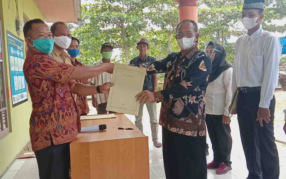 Camat Kapuas Kuala, Inop dampingi Kepala Desa Wargo Mulyo menyerahkan piagam ke anggota BPD yang lama.