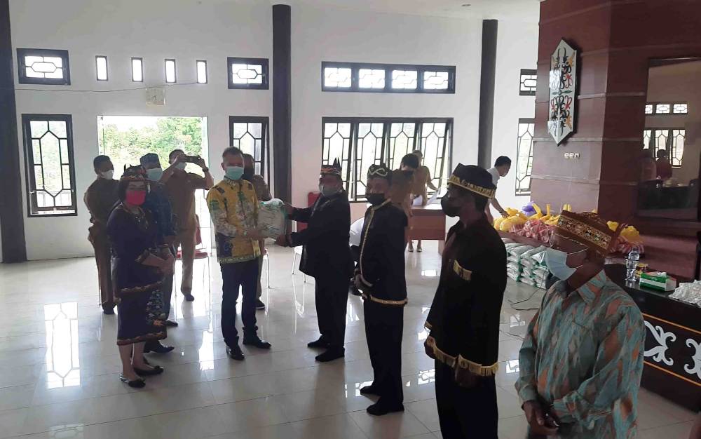Ketua DAD Kabupaten Gumas, Jaya S Monong menyalurkan bantuan secara simbolis kepada tokoh adat dan masyarakat terdampak banjir.