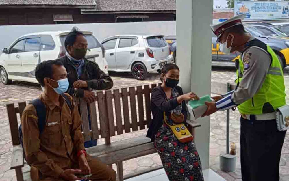 Anggota Polres Sukamara saat membagikan masker kepada masyarakat. (foto : dokumentasi Borneonews)