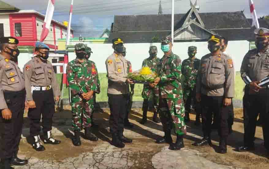 Kapolres Seruyan AKBP Bayu Wicaksono menyerahkan serahkan tumpeng kepada Perwira Penghubung Kodim 1015 Sampit,  Mayor Arh Bambang Waluyo.