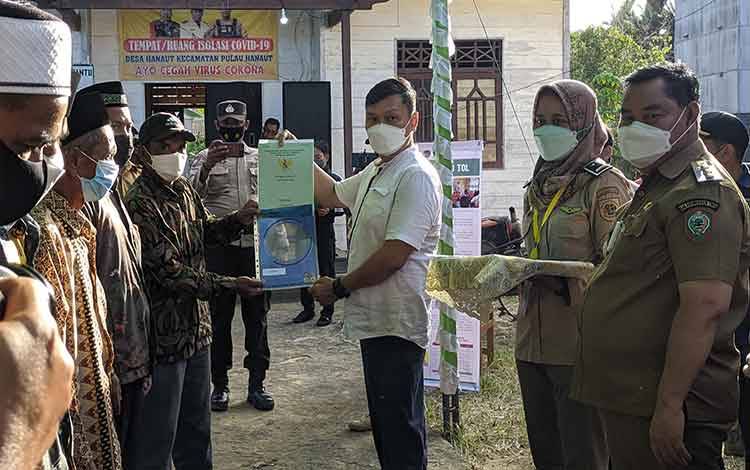 Wamen ATR/BPN Surya Tjandra saat menyerahkan sertifikat tanah secara simbolis terhadap warga Desa Hanaut. 