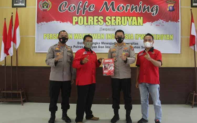 Kapolres Seruyan AKBP Bayu Wicaksono, menyerahkan tabloid Polres Seruyan kepada Ketua PWI Seruyan M Yadi pada kegiatan Coffe Morning