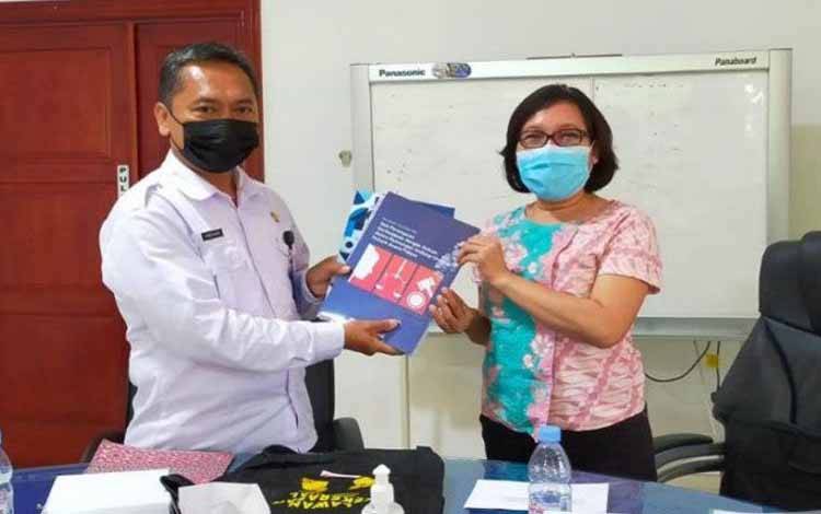 Pelaksana Tugas Kadinsos Kalteng Farid Wajdi menerima buku terbitan Komnas Perempuan di Palangka Raya, Rabu (6/10/2021)