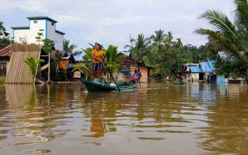 Warga Desa Sungai Puring, Kecamatan Antang Kalang terpaksa beraktivitas menggunakan perahu karena terkepung banjir.