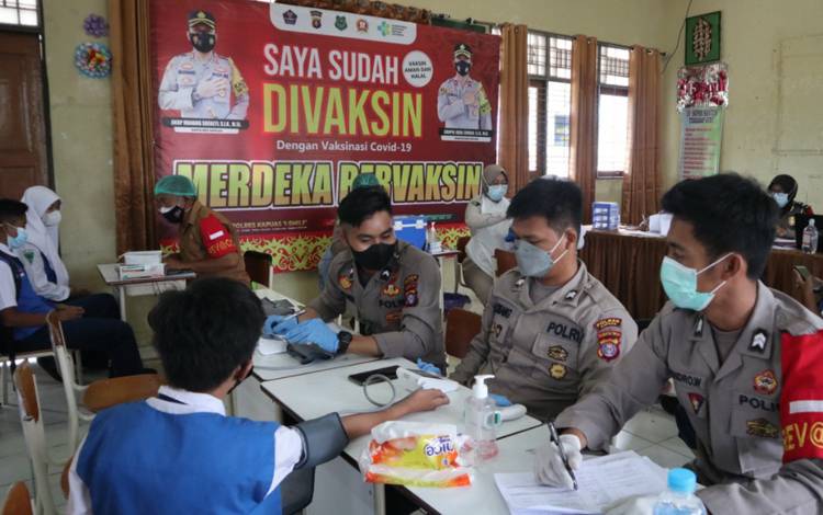 Personel Polres Kapuas saat melakukan vaksinasi kepada pelajar SMPN 2 Kuala Kapuas, Selasa, 12 Oktober 2021.
