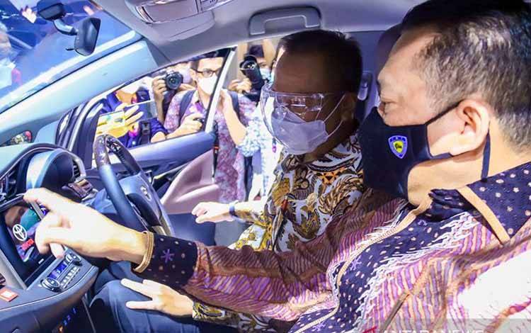 Menteri Perindustrian Agus Gumiwang Kartasasmita (kiri) bersama Ketua MPR RI yang juga Ketua Umum Ikatan Motor Indonesia (IMI) Bambang Soesatyo (kanan) memperhatikan interior kendaraan listrik yang ditampikan pada Pameran Indonesia International Motor Show (IIMS) Hybrid 2021 di Jakarta, Kamis (15/4/2021)