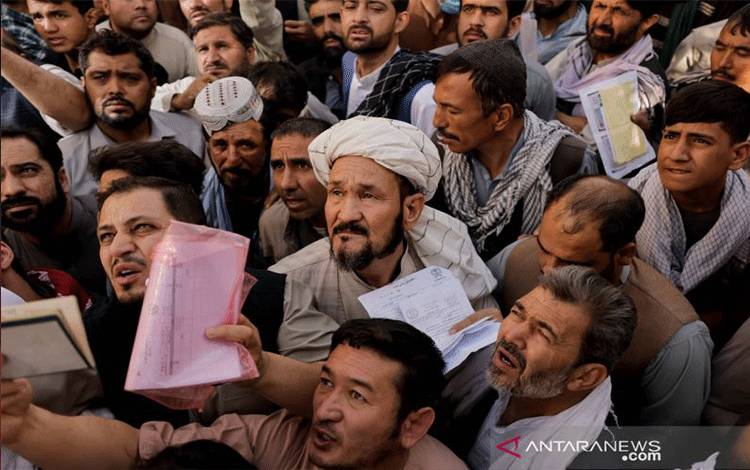 Arsip - Puluhan warga Afghanisatan berada di depan kantor urusan paspor di Kabul, Afghanistan, Rabu (6/10/2021), setelah para pejabat Taliban mengumumkan mereka akan mulai menerbitkan paspor kembali bagi warga, menyusul penundaan berbulan-bulan yang menghambat upaya warga untuk meninggalkan negara itu setelah Taliban mengambil alih kekuasaan. ANTARA FOTO/REUTERS/Jorge Silva/HP/djo