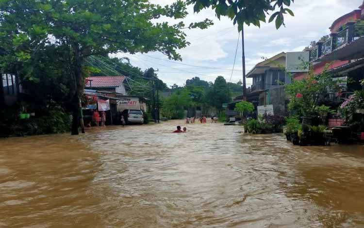 Sejumlah anak sedang bermain banjir di Jalan Mugirejo, Kelurahan Mugirejo, Senin (18/10/2021)