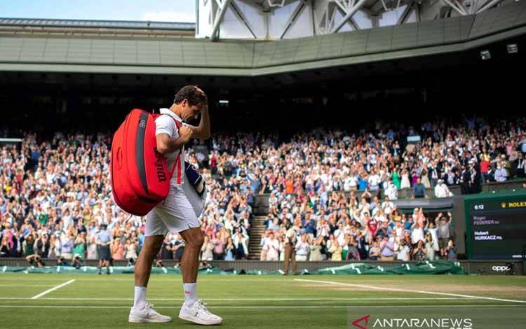 Petenis Swiss Roger Federer meninggalkan lapangan seusai dikalahkan petenis Polandia Hubert Hurkacz dalam perempat final turnamen Wimbledon di London, Inggris, Rabu (7/7/2021)